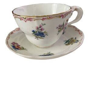 Teacup and saucer, unmarked with flowers and gold trim.
